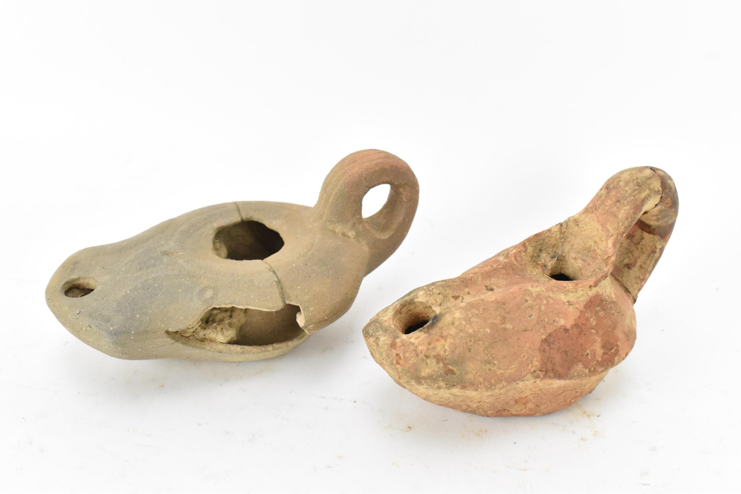 A collection of Roman pottery to include two terracotta oil lamps, a pot, a crescent shaped handle - Image 7 of 8