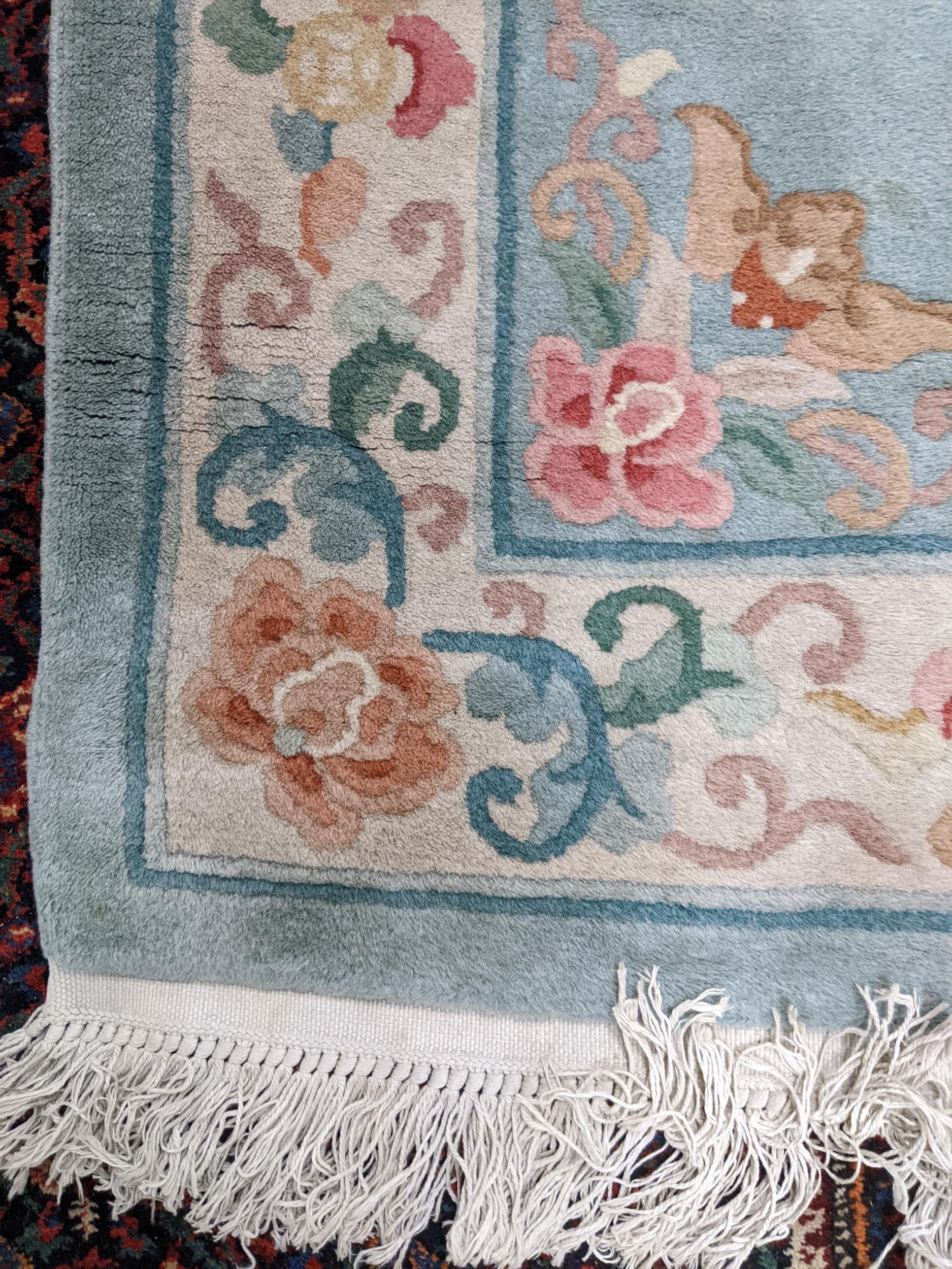 A Chinese floral patterned runner on a light blue and cream ground 321cm x 86cm Location: - Image 3 of 6