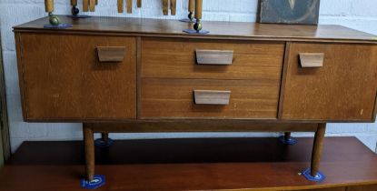 A mid century Scandinavian teak sideboard, wo central drawers flanked by twin cupboard doors, on