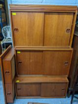 A mid century teak veneered modular wall unit, comprising a two drawer top, three open shelves and