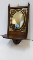 An early 20th century oak and brass bracket with a mirrored back and folding shelf, 42cm x 21cm