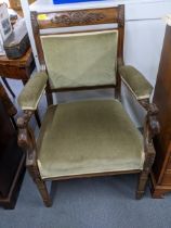 An Edwardian walnut carved and upholstered open armchair, the arms with carved, scrolled leaf and