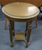 An early/mid 20th century French gilt painted circular topped two tier table having a beaded top and