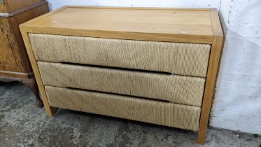 A modern light oak chest of three drawers, the drawer fronts with woven decoration, 75.5h x 120w