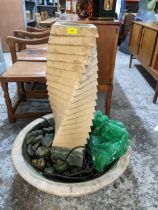 A weathered garden stone fountain, circular base with twisted and stepped column Location: