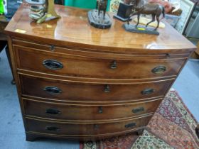 A reproduction bow fronted mahogany chest, four graduated drawers with key to each drawer, below a