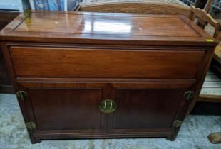 A Chinese rosewood side cabinet with hinged top, twin cupboard doors revealing a fitted