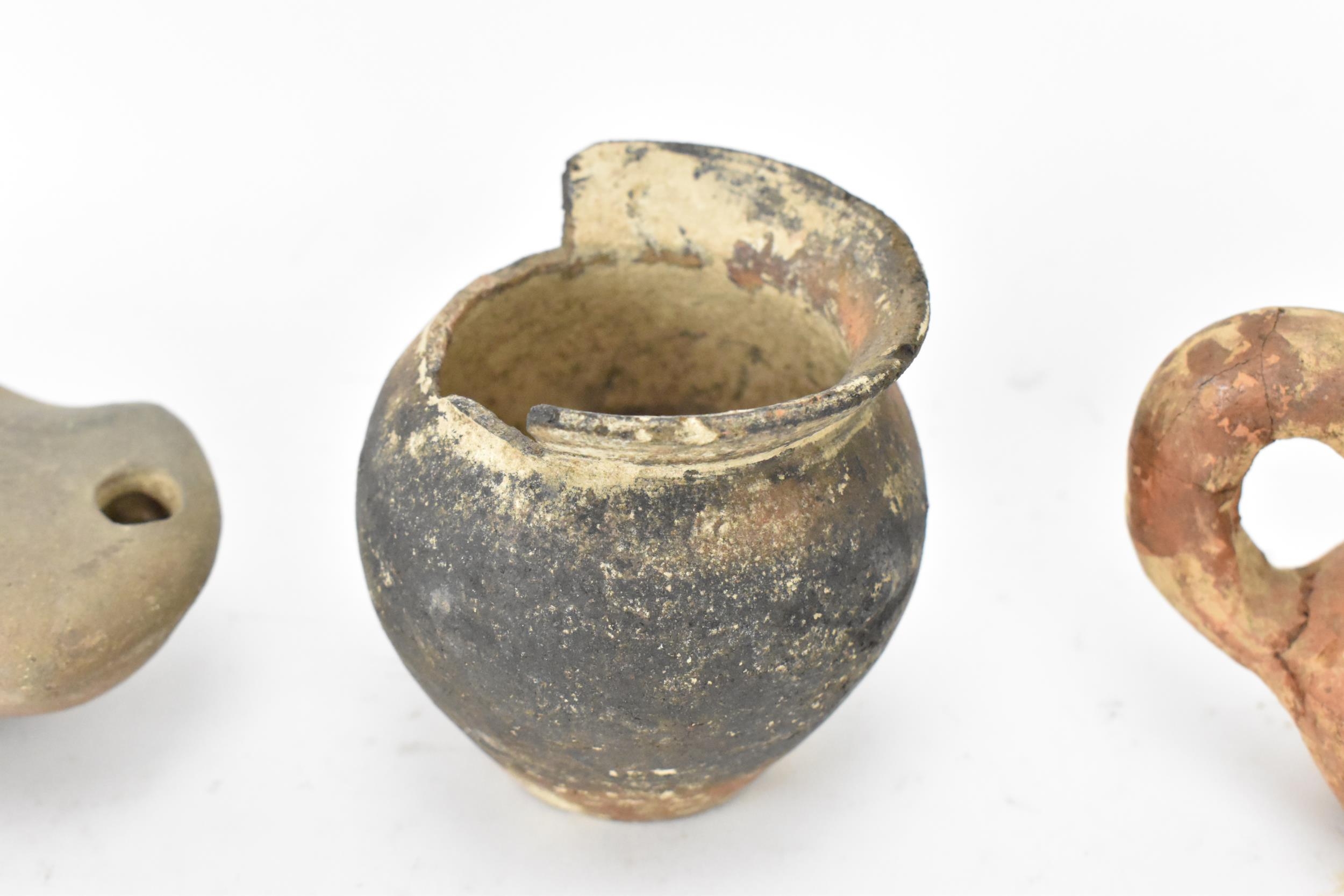 A collection of Roman pottery to include two terracotta oil lamps, a pot, a crescent shaped handle - Image 4 of 8