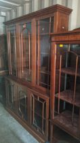 A late 20th century mahogany bookcase cabinet with glazed, panelled doors, locked, on a plinth,