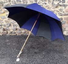 A mid 20th Century cane handled umbrella in black and navy with painted porcelain handle and