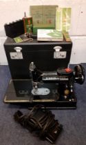 A 1955 Singer Featherweight 222K electric sewing machine with accessories and black travel case