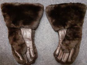 A pair of brown beaver lamb and brown leather gloves with wide cuffs and cream shearling lining.