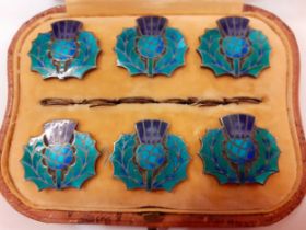 A cased set of 6 silver and enamelled buttons fashioned as thistles in a South African Leo Simmons