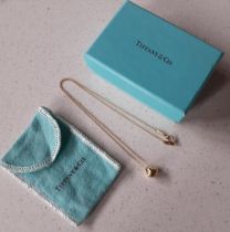 Tiffany & Co-An 18ct gold nugget charm on an 18ct gold chain stamped 750, 3.5g, together with