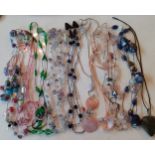 A quantity of modern stone and glass bead necklaces mostly on string and leather straps to include
