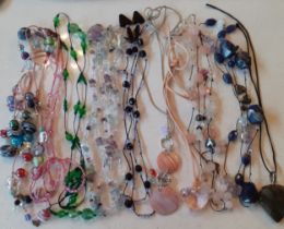 A quantity of modern stone and glass bead necklaces mostly on string and leather straps to include