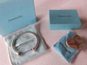 Tiffany & Co-A silver horse shoe design bangle together with a Tiffany silver heart shaped pill box,