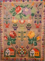 A 1928 wool cross stitch sampler, unframed, with flowers in pots, roses and buildings, 36cm x