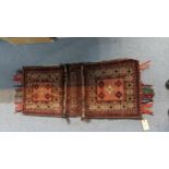 A Persian saddle bag rug having geometric motifs on a red ground 49cm w x 125cm l Location:G