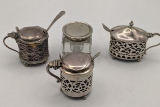 Three silver condiments all having a pierced design along with a crystal cut inkwell pot having a