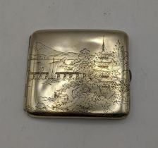 A Japanese sterling silver cigarette case with an etched Japanese mountain scene, inlaid interior,