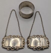 Two silver decanter labels having embossed floral edges to include a Gin and Sherry label, and a