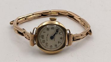 An early 20th century 9ct gold ladies manual wind wrist watch on a yellow metal expanding