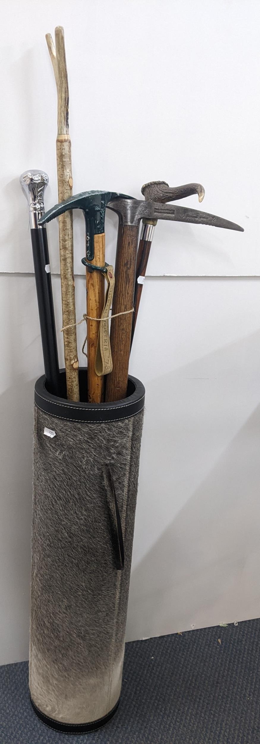 A fur and leather stick stand containing walking sticks and pick axes to include a horn handled