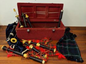 Bone and resin component parts of bagpipes with tartan tassels in a red carrying case, maybe