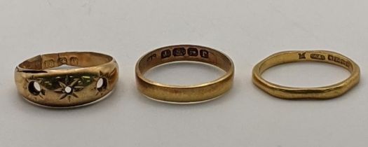 Two 22ct gold wedding bands, 4.3g together with an 18ct gold gypsy ring with the stones missing 1.6g
