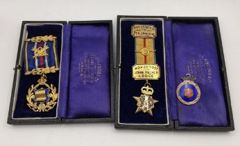 Two 1930s cased silver gilt masonic medals with ribbons and a 1920s silver masonic badge