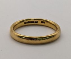 A 22ct gold wedding band size R½, weight 5.7g Location: