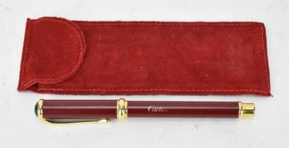 A Must De Cartier fountain pen with a red lacquer case and lid, with gold plated detail and having