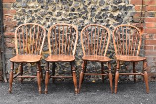 A set of four 19th century elm and ash Windsor dining chairs, having spindle hoop shaped backs,