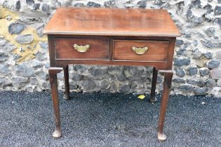 A George II mahogany lowboy, having a rectangular top with rounded corners, two drawers with brass