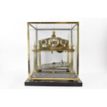 A 20th century Congreve clock, housed in glass display cabinet, having three silvered chapter rings,