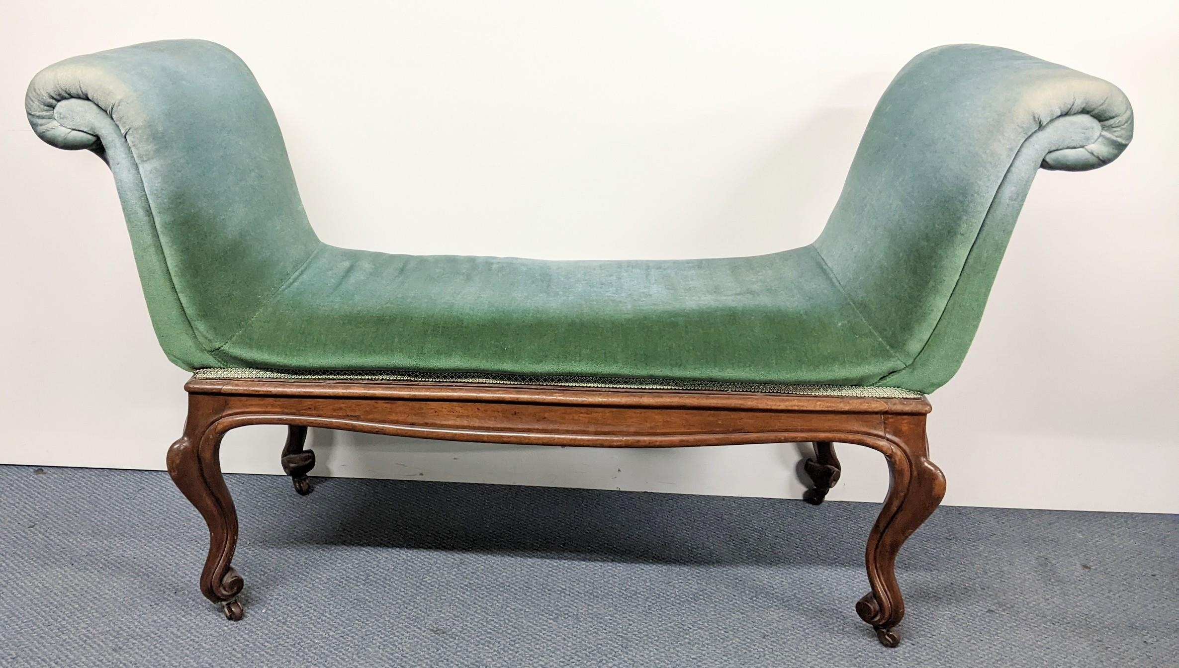 A 19th century French walnut window seat having padded scroll ends, cabriole legs with carved scroll