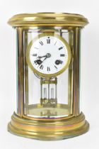 A late 19th/early 20th century French mantle clock, having a lacquered brass case with curved