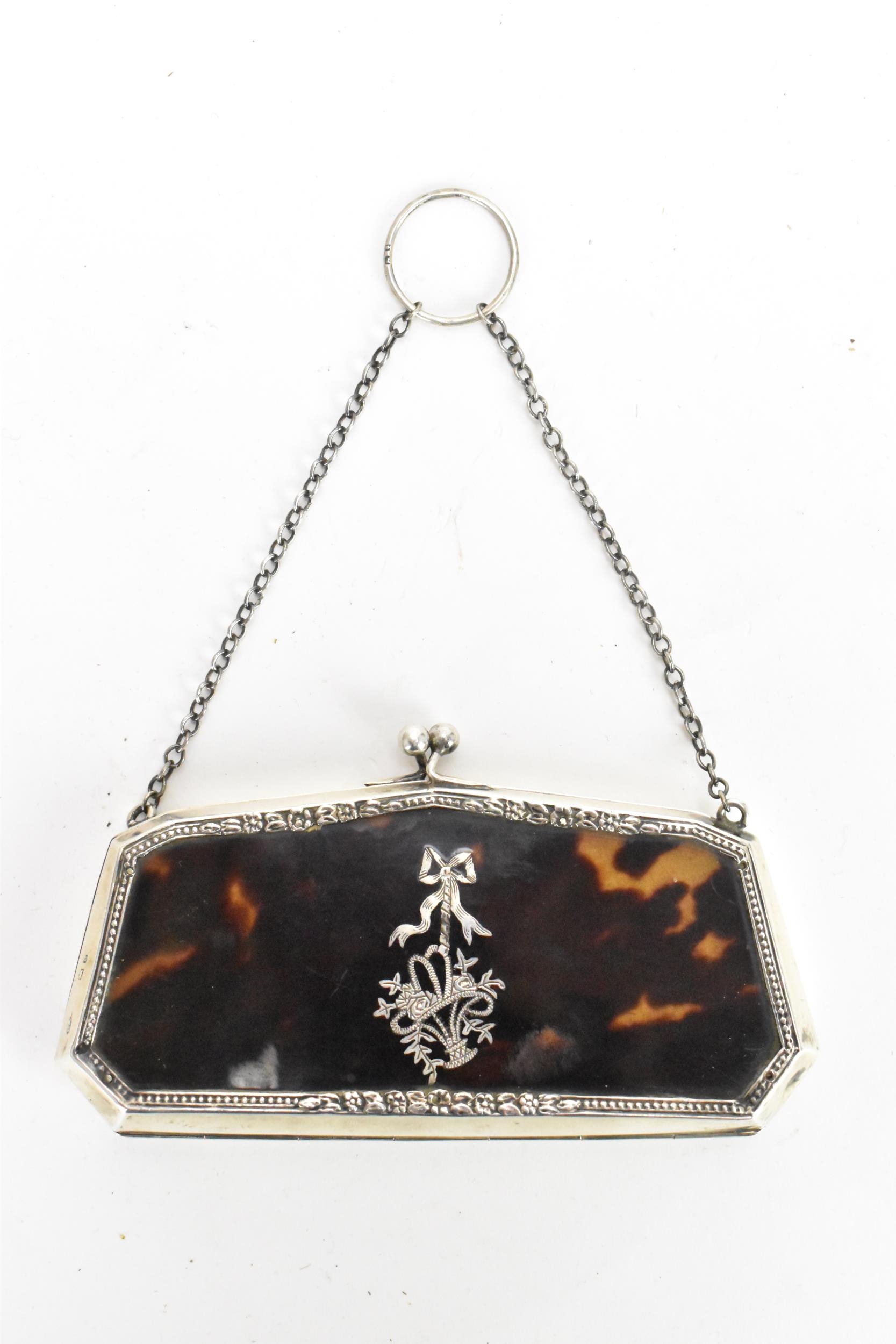 A George V tortoiseshell and silver purse, with suspension chain, Adams style silver inlaid