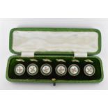 A set of 9ct mounted dress studs with faux mother of pearl and green enamel detail and woven chain