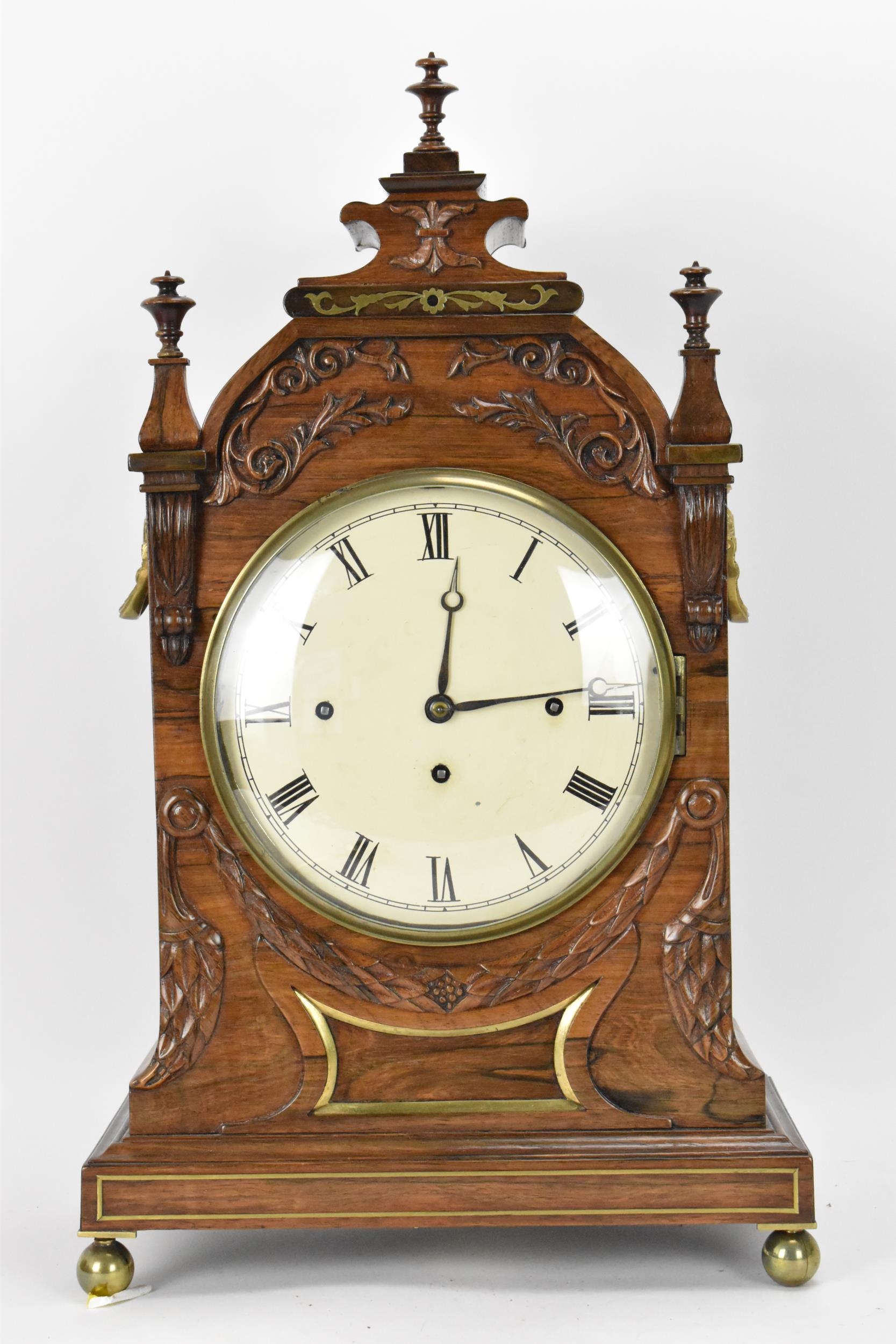 A William IV rosewood bracket clock, the case having three turned finials, applied floral scroll