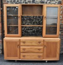 An Ercol Windsor range light elm display cabinet, having three open shelves flanked by two glazed