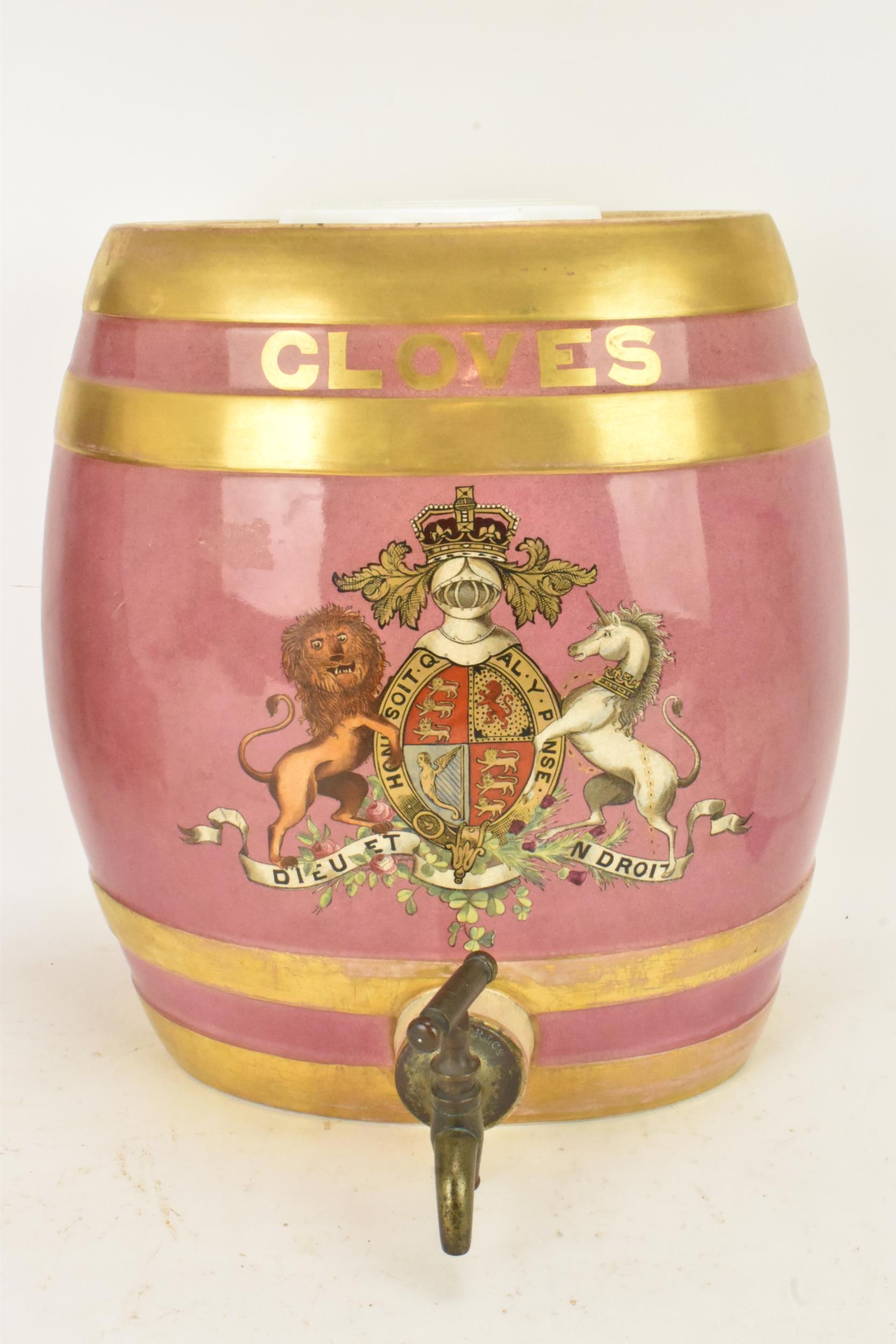 A Victorian ceramic cloves barrel, of oval shape and decorated with a pink ground with gilt bands