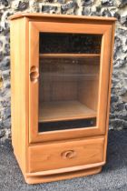 A vintage Ercol Windsor range light elm hi-fi cabinet, having a single bevelled glazed door,