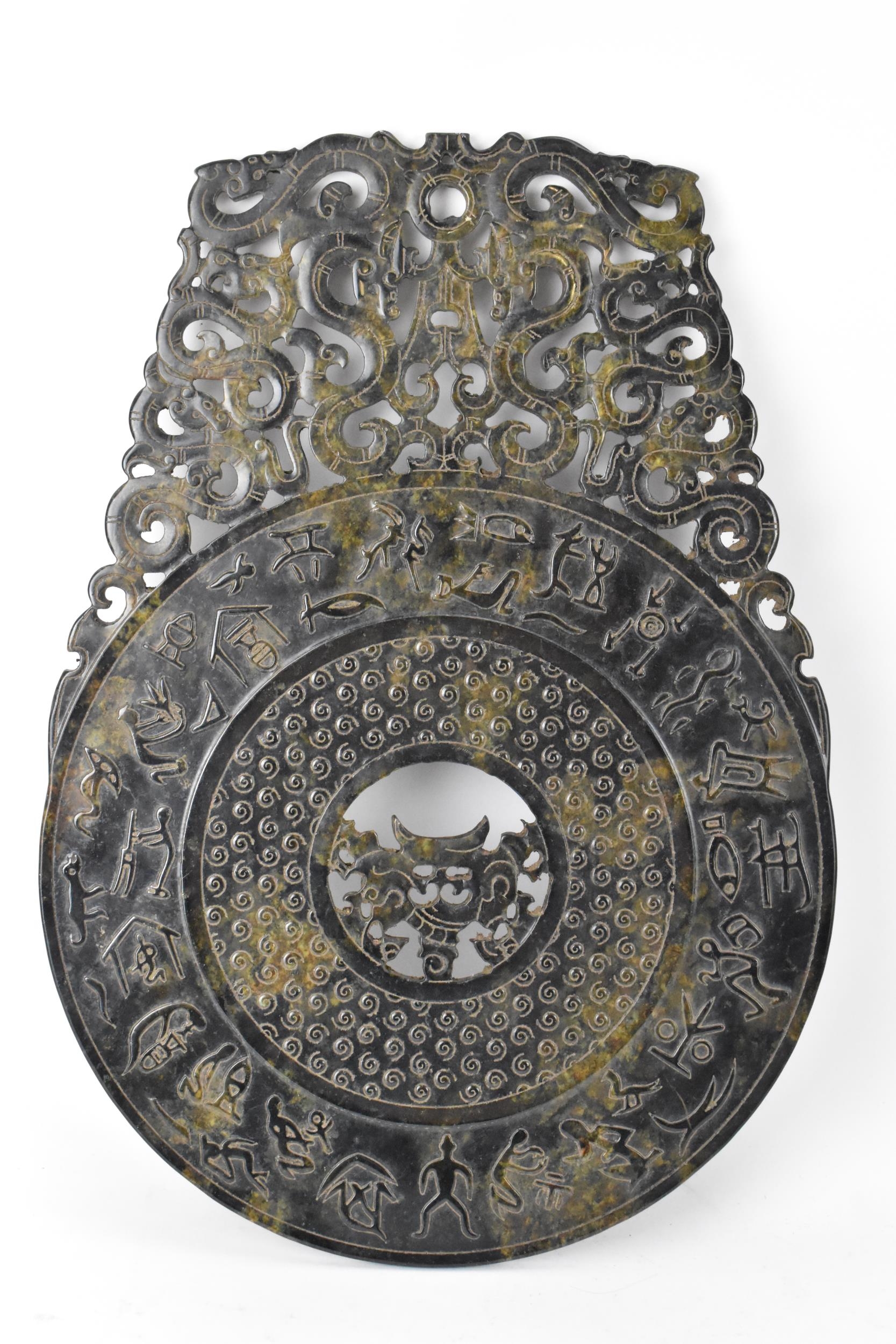 A Chinese nephrite jade BI disk, relief carved with ancient script, repeated motif, pierced