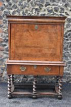 An early 18th century walnut quarter cut secretaire chest on a later stand, having a cavetto moulded