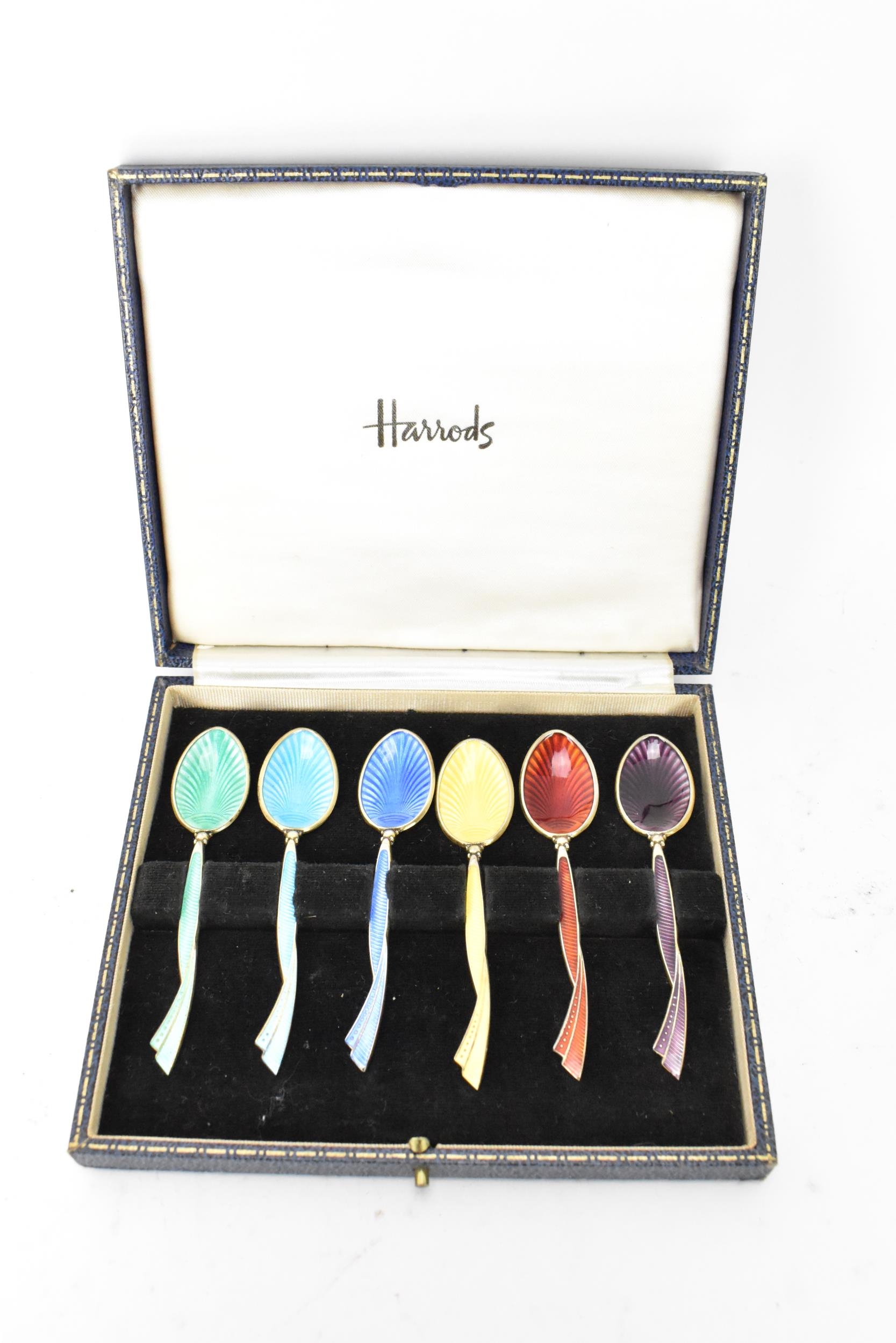 A cased set of six mid 20th century coffee bean spoons, retailed by Harrods, all having guilloche
