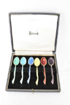 A cased set of six mid 20th century coffee bean spoons, retailed by Harrods, all having guilloche