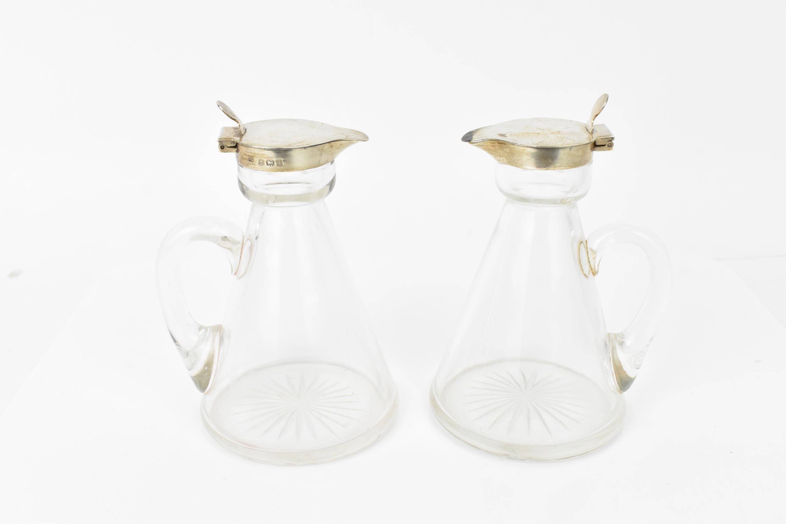 A pair of Edwardian silver mounted whisky tots by Hukin & Heath, Birmingham 1908, each with glass