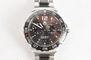 A Tag Heuer Formula 1, quartz, alarm, gents, stainless steel wristwatch, having a black dial, two